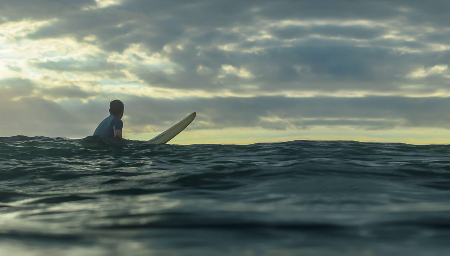 Surfer floating at sunset in Nosara, Costa Rica