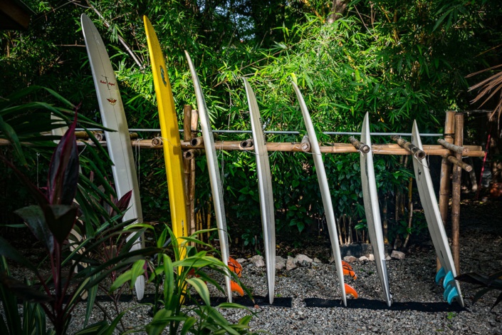 Different sized surfboards on bamboo rack at Corky Carroll's Surf Resort