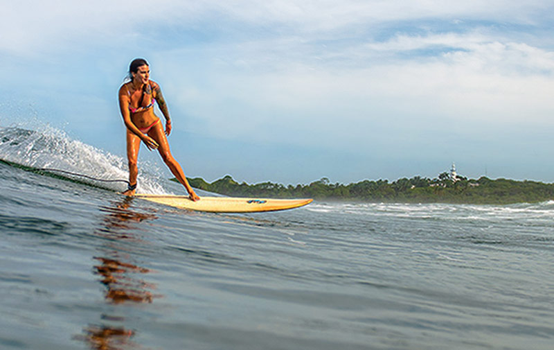 Woman surfing Playa Guiones in Nosara, Costa Rica